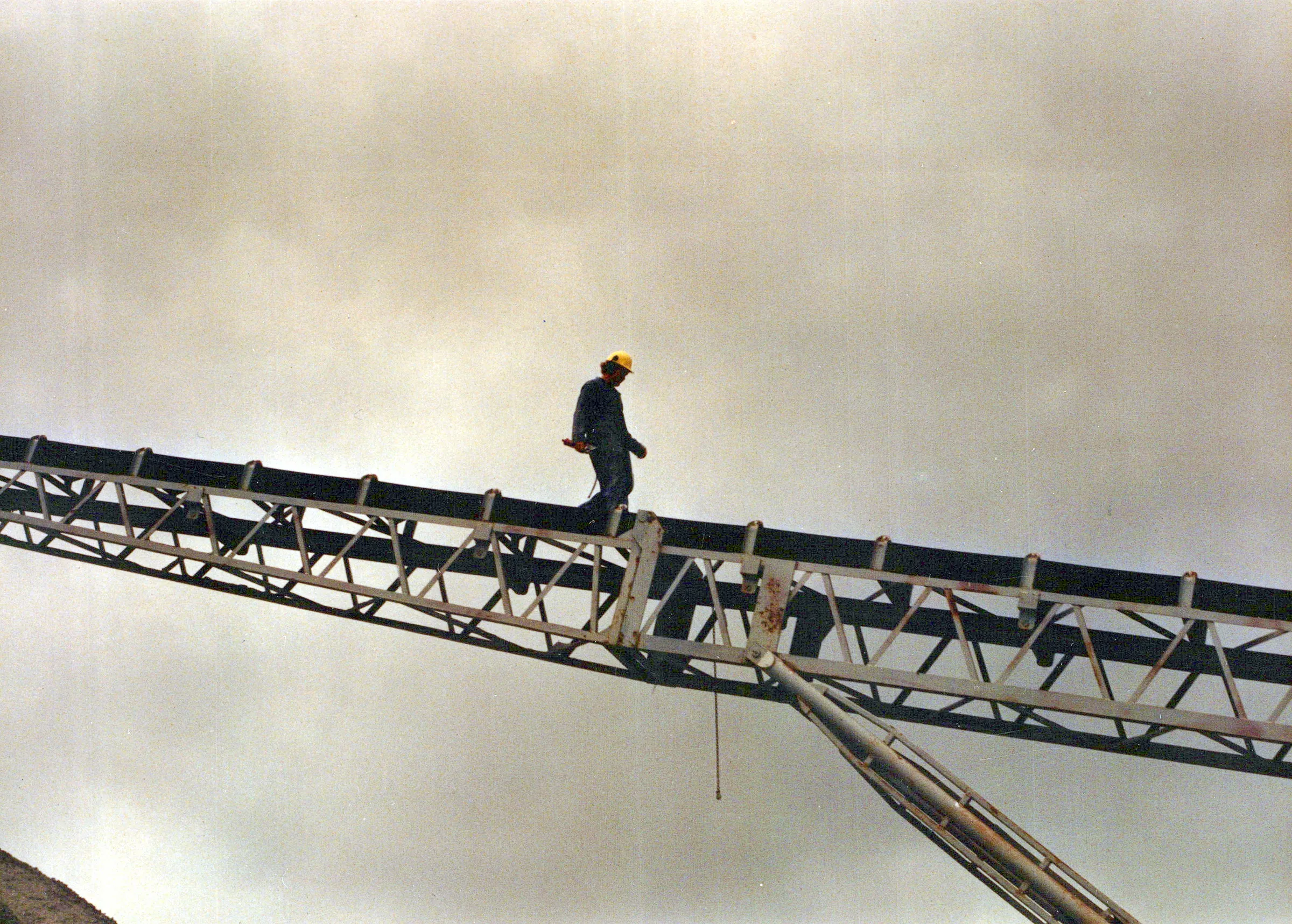 JDA worker walking an elevated conveyor belt structure